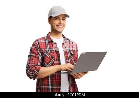 Young man with a cap holding a laptop computer and smiling at the camera isolated on white background Stock Photo