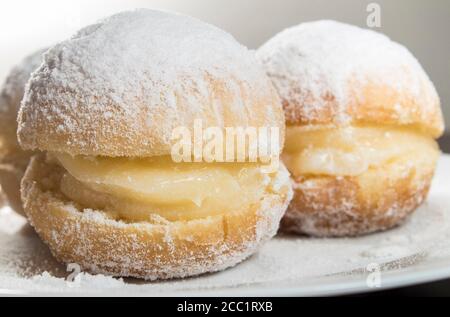 Brazilian cream doughnuts know as 'Sonho de padaria'. It's the brazilian version of Berliner. Filled with vanilla cream and sprinkled with sugar. Stock Photo