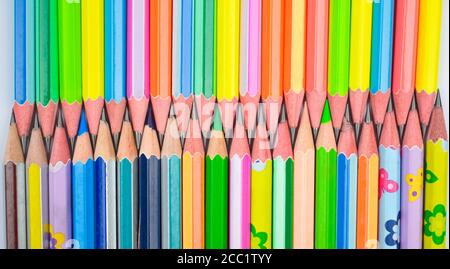 Attached row of many different colored wood pencil crayons with sharpened tip Stock Photo