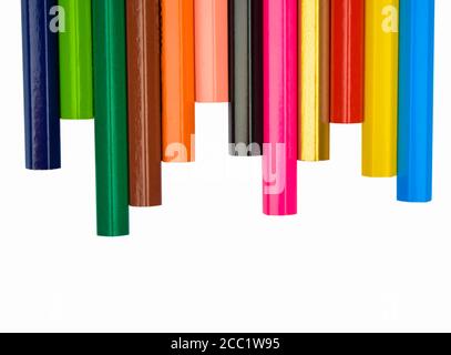 Heap of various colored wood pencil crayons scattered across a white paper background Stock Photo