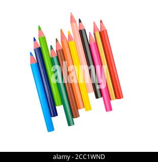 Stack of different colored wood pencil crayons scattered across a white paper background Stock Photo