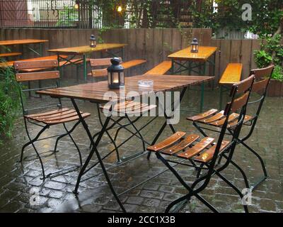 Germany, Hessen, Frankfurt, Empty table and chairs wet in rainwater at garden Stock Photo