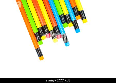 Various colored wood pencil crayons scattered across a white paper background Stock Photo