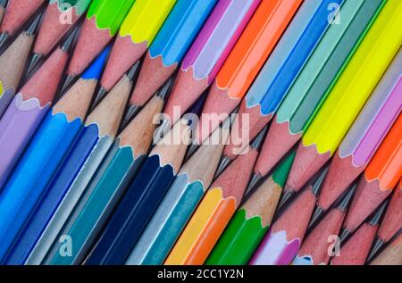 An attached row of many different colored wood pencil crayons with sharpened tip Stock Photo
