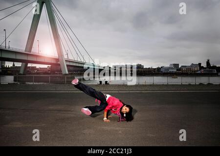 Germany, Cologne, Young woman performing break-dance, portrait Stock Photo