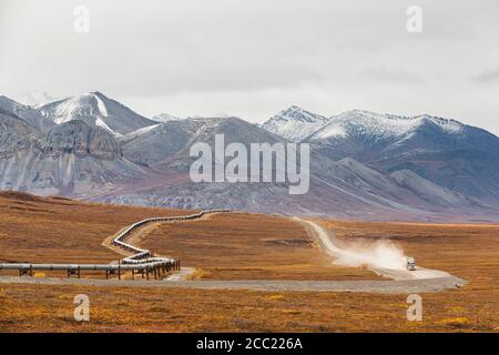 USA, Alaska, View of Trans Alaska Pipeline System along Dalton Highway with truck in autumn and Brooks Range Stock Photo