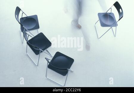 Man between chairs, elevated view Stock Photo