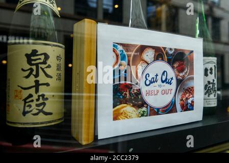 London, UK.  17 August 2020. Promotional signage outside a Japanese restaurant in Soho which is participating in the UK government's 'Eat Out to Help Out Scheme'.  Diners receive a 50% discount (up to £10) on food or non-alcoholic drinks to eat or drink in, every Monday, Tuesday and Wednesday between 3 and 31 August.  The scheme is aimed at boosting the revenues of the hospitality industry which has been hard hit during the ongoing coronavirus pandemic. Credit: Stephen Chung / Alamy Live News Stock Photo