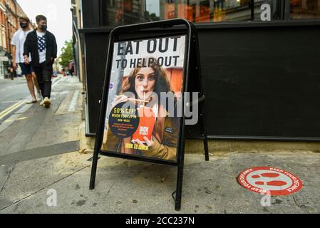 London, UK.  17 August 2020. Promotional signage outside a restaurant in Soho which is participating in the UK government's 'Eat Out to Help Out Scheme'.  Diners receive a 50% discount (up to £10) on food or non-alcoholic drinks to eat or drink in, every Monday, Tuesday and Wednesday between 3 and 31 August.  The scheme is aimed at boosting the revenues of the hospitality industry which has been hard hit during the ongoing coronavirus pandemic. Credit: Stephen Chung / Alamy Live News Stock Photo