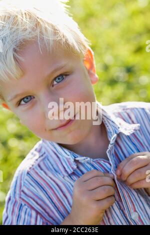 Little boy (2-3) buttoning up his shirt, portrait Stock Photo