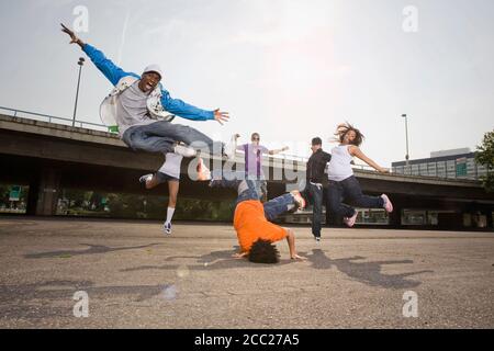Germany, Cologne, Group of people breakdancing on street Stock Photo
