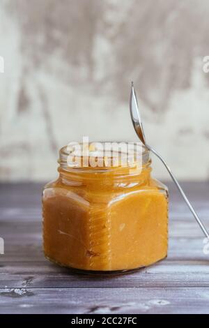 homemade caramel in a jar with a spoon Stock Photo