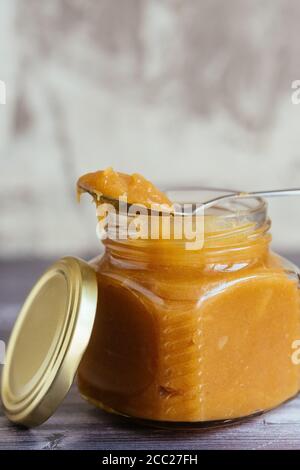 homemade caramel in a jar with a spoon Stock Photo