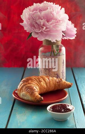 Croissant with strawberry jam on wooden table, close up Stock Photo