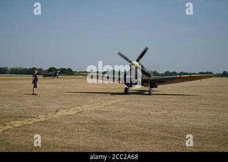 A pair of Spitfire fighter planes at Headcorn airfield in Kent. Taxiing after landing. Stock Photo