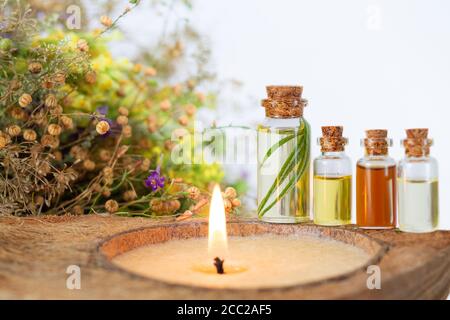 Spa set with burning candle, essential oils in bottles, herbs and flower. Space for your text Stock Photo