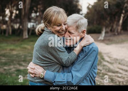 Close up portrait of senior adult couple embracing in forest Stock Photo