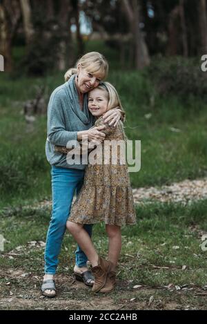 Close up of grandmother and granddaughter smiling in field Stock Photo