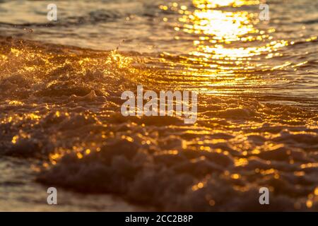 Germany,  Schleswig Holstein, Sun reflecting on surface of water at sunset Stock Photo