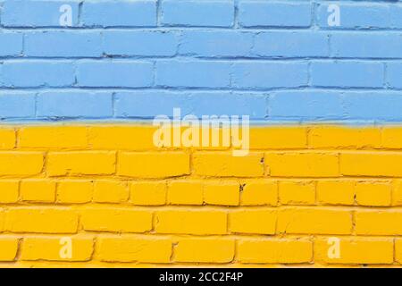 Painted brick wall in the colors of the Ukrainian flag. Stock Photo