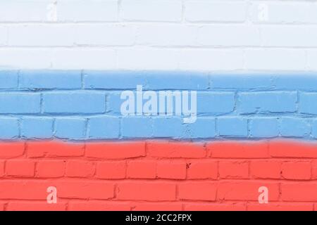 A painted brick wall in the colors of the flag of Russia. Stock Photo
