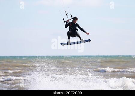 Camber, East Sussex, UK. 17 Aug, 2020. UK Weather: The wind has picked up which is Ideal for these kite surfers who take advantage of the blustery conditions at Camber in East Sussex. Photo Credit: Paul Lawrenson-PAL Media/Alamy Live News Stock Photo