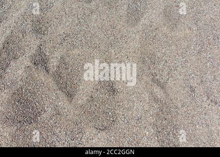 Coarse sand background texture. Close up of coarse sand grains. Stock Photo
