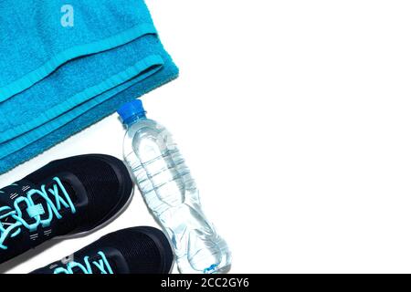 Towel and athletic shoes, bottle of water, the concept of a healthy lifestyle, healthy diet, sport and diet. Stock Photo