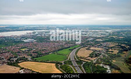 Horizontal aerial view of Essex with the A13 in the foreground and QEII bridge or the Dartford crossing in the background.