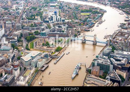 Horizontal aerial view of HMS Belfast, City Hall, Tower of London and Tower Bridge looking easterly over London. Stock Photo