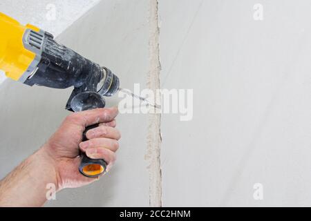 drill hole for electrical outlet outlet, special power tool drill. Stock Photo