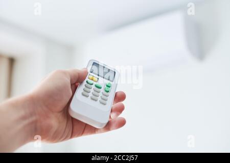 Remote control for air conditioner in hand. Room condition remote control. Air temperature switch for cooling of space. Stock Photo