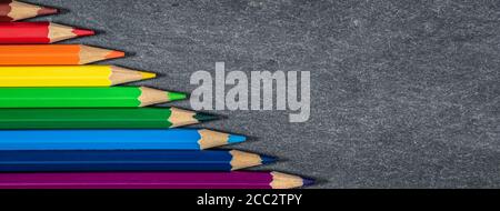 Colored pencils on slate background. Drawing and art banner. Stock Photo