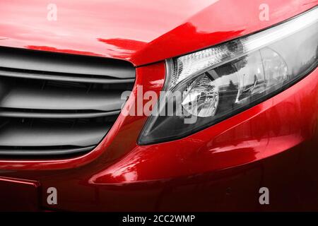 Red car. Front view of a new car. Modern car close up. Car background. Stock Photo