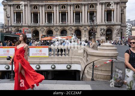 Academy national of music with entrance in background. Photo shooting with Model in red with metro in foreground. Paris - France, 31. may 2019 Stock Photo