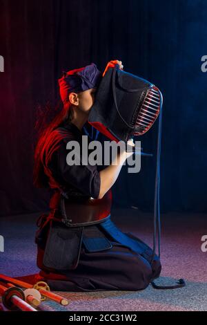 young caucasian woman kendo fighter wear mask helmet on head, going to practice kendo fighting. kendo is a way to discipline the human character throu Stock Photo