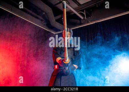 kendo combat warrior in traditional dress on smoky background, before competitions. man keen on traditional japanese martial art. Training, power. Stock Photo