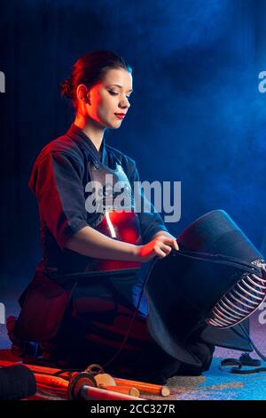 young caucasian woman kendo fighter wear mask helmet on head, going to practice kendo fighting. kendo is a way to discipline the human character throu Stock Photo