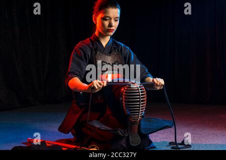 caucasian female keen on kendo activity, combining martial arts practices and values with strenuous sport-like physical activity. wearing special suit Stock Photo