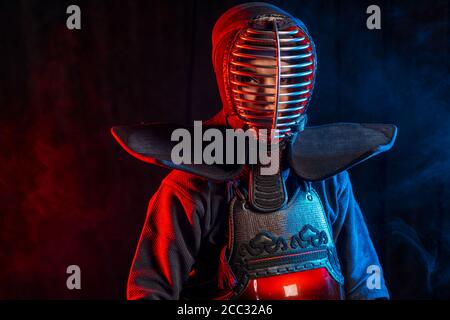 kendo girls concept. female kendo fighter keen on traditional martial art, person in armor. using bamboo swords shinai and protective armour Stock Photo