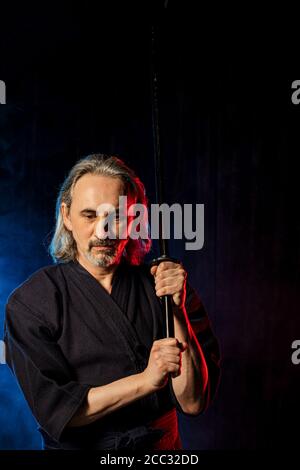 strong caucasian kendo fighter in traditional clothes. japanese martial arts, combat warrior, samurai concept. using shinai for fighting Stock Photo