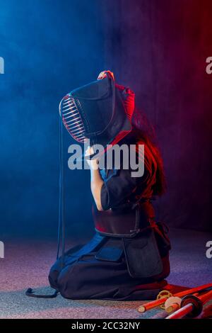 young caucasian female kendo fighter wearing mask, woman in kendo suit keen on traditional martial art Stock Photo