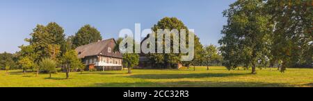 timbered cottage - czech traditional wooden timbered house with trees nearby Stock Photo