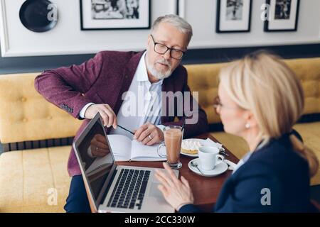 new colleague consulting with experienced chef. close up photo. man sharing with knowledge or information with a woman Stock Photo