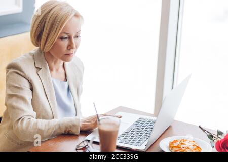 attractive woman having some problems with a computer. woman has read unhappy news, information , close up side view photo Stock Photo