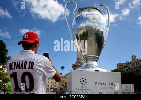 Lisbon, Portugal. 17th Aug, 2020. A fan wearing a Paris Saint-Germain's Brazilian forward Neymar shirt takes a picture of a giant replica of the UEFA Champions League trophy displayed at Rossio square in downtown Lisbon, Portugal on August 17, 2020, during the UEFA Champions League Finals. Credit: Pedro Fiuza/ZUMA Wire/Alamy Live News Stock Photo