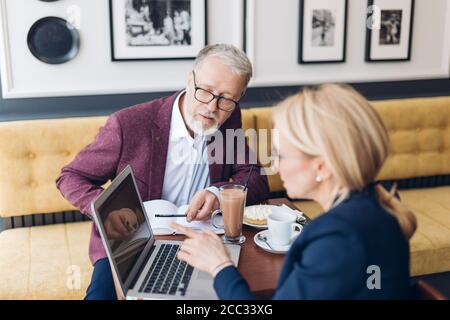 creative businesswoman pointing to the laptop and sharing with her ideas while drinking tea. close up photo. creativity concept Stock Photo