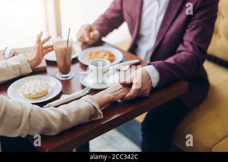 man holding woman's hand and taking with her during breakfast . close up cropped photo Stock Photo
