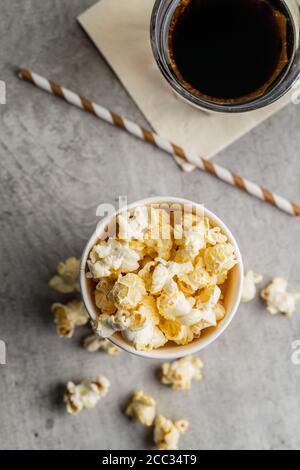 Sweet tasty popcorn in cup and glass of cola. Top view. Stock Photo