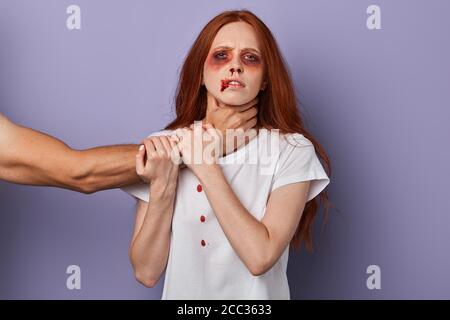 scared woman trying to stop her angry husband who wants to kill her. closeup portrait, studio shot, social problem, revenge concept Stock Photo